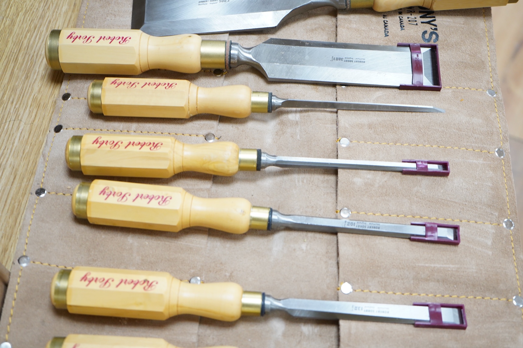 Two sets of Robert Sorby woodworking chisels, both in Kuny’s of Canada leather tool rolls; a nine piece set with octagonal handles, together with a six piece set with rosewood handles